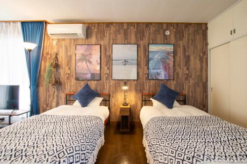 two beds in a room with wooden walls at Villent Kujukuri Ocean 2 in Kujukuri