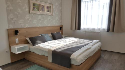 Un dormitorio con una cama grande y una ventana en Lelle Resort CB34, en Balatonlelle
