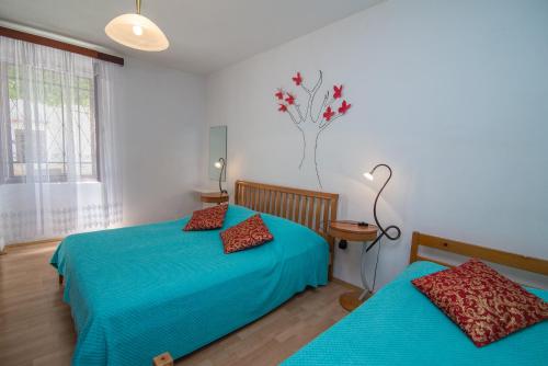 1 dormitorio con 2 camas con sábanas azules y ventana en Andjelka B4-Blue en Mali Lošinj