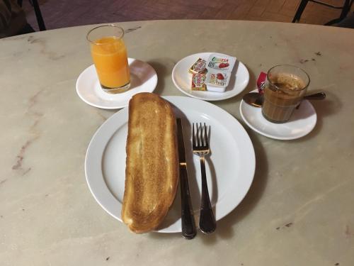 einen Tisch mit einem Teller mit einem Stück Brot und Getränken in der Unterkunft Hostal Moraleda ** in Piedrabuena