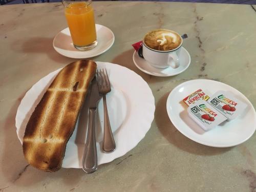 einen Tisch mit zwei Brotplatten und einer Tasse Kaffee in der Unterkunft Hostal Moraleda ** in Piedrabuena