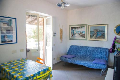a living room with a blue couch and a table at casa delle palme in Ustica