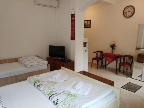 Apartment Monika في كوتور: غرفة نوم بسريرين وطاولة وكراسي