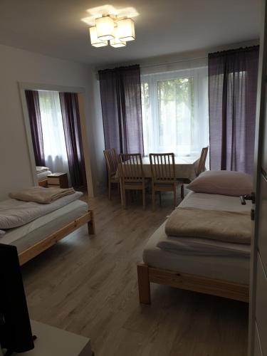 - une chambre avec 2 lits, une table et des chaises dans l'établissement Mieszkanie dla 3-6 osób, à Pruszków