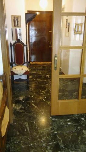 a hallway with a door and a chair in a room at CHRYSSA - ΧΡΥΣΑ in Patra