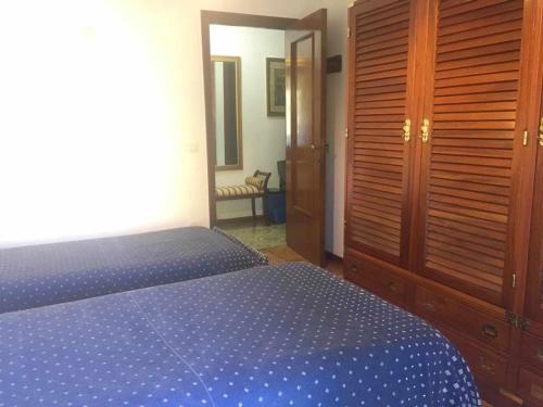 a bedroom with a blue bed and a wooden closet at Betti 21 in Rapallo