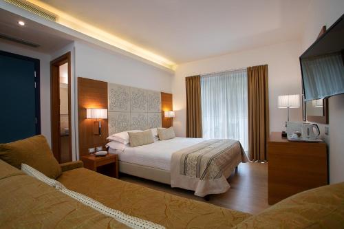 um quarto de hotel com uma cama e uma televisão em Hotel Daniele em Lignano Sabbiadoro