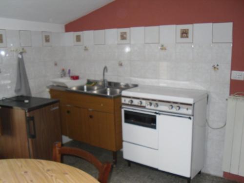 a kitchen with a white stove and a sink at Appartamenti Il Leone in Pienza