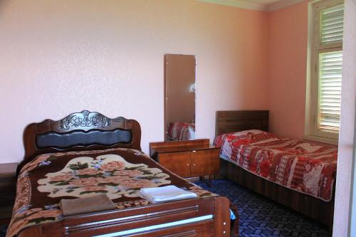 a bedroom with two beds and a mirror at Guest House Shota in Sighnaghi