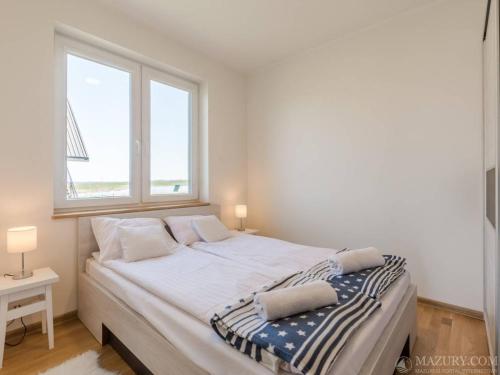 a large bed in a room with two windows at Sterla - Masuria in Giżycko