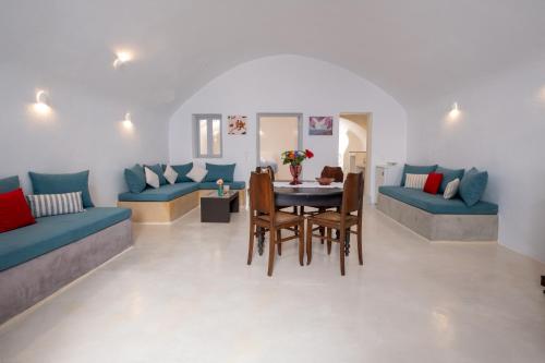 a living room with blue couches and a table and chairs at Labyrinth Traditional Houses in Pirgos
