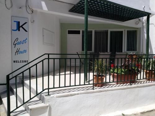 a balcony of a house with a fence and plants at JK's GUESTHOUSE KARDAMAINA in Kardamaina