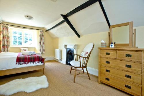 a bedroom with a bed and a dresser and a chair at Little Combe in Chard
