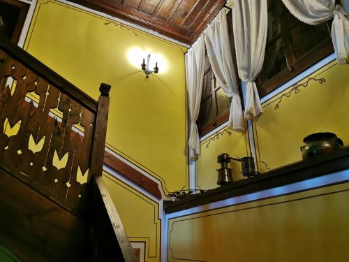 コプリフシティツァにあるHadji Neikovi Guest Housesの黄色の壁と窓のある部屋