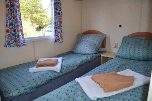 two beds in a room with towels on them at ZATOR Noclegi u Babci Józi in Zator