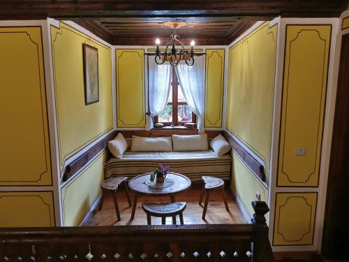 コプリフシティツァにあるHadji Neikovi Guest Housesのテーブルと窓が備わる小さな客室です。