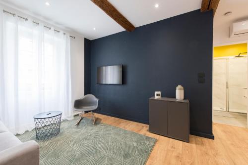 un salon avec un mur bleu et une chaise dans l'établissement APPARTEMENT 1 NEUF sur le port à coté de la plage, à Saint-Raphaël