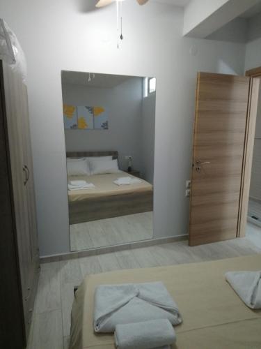 a bedroom with a mirror and a bed in it at JK's GUESTHOUSE KARDAMAINA in Kardamaina