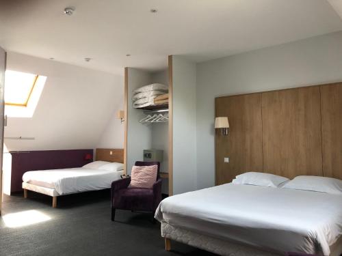 a hotel room with two beds and a chair at Logis L'Hôtel D'Arc in Arc-sur-Tille