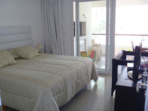 una camera da letto bianca con un letto, una scrivania e una finestra di Green Park - Lloret de Mar Punta del Este a Punta del Este