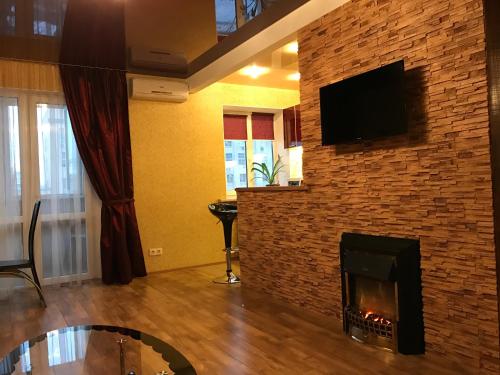a living room with a fireplace with a tv on a brick wall at New apartments with panoramic views on Avenue Nauky in Kharkiv