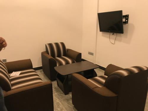a waiting room with chairs and a tv and a table at Duvi's Shelter Bungalow in Colombo