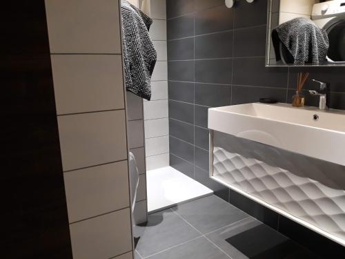 a bathroom with a white sink and a toilet at La maison des savoyards in Husseren-Wesserling