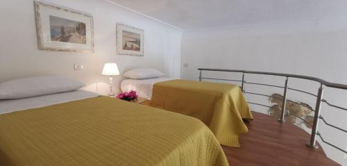 une chambre d'hôtel avec deux lits et une lampe dans l'établissement luxury Apartment Carmen n 2 Centro Storico di Taormina, à Taormine