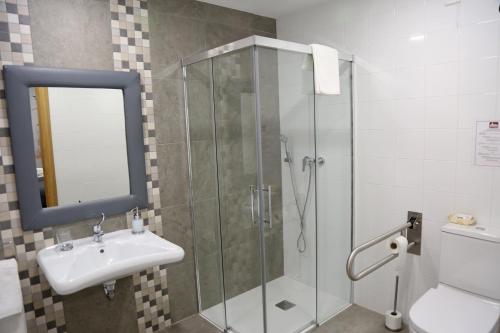 a bathroom with a glass shower and a sink at Hostal Rural Villa de Mendavia in Mondaria