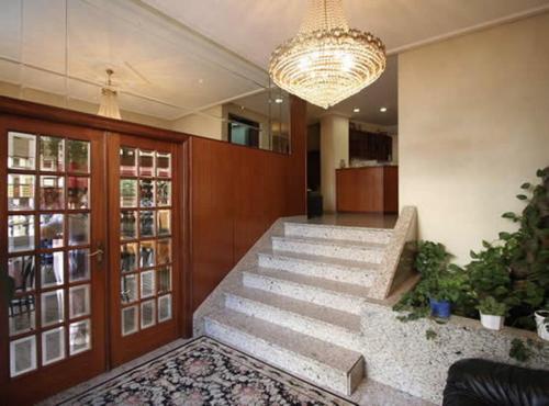 a lobby with stairs and a chandelier at Hotel Cristaleiro in Gondomar