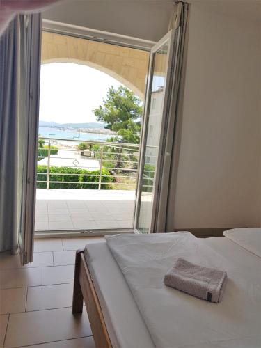 a bedroom with a bed and a large window at Apartments Palaca Sunca in Srima