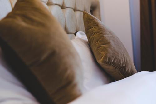 two brown pillows sitting on top of a bed at Casa Muntenească Alessandro in Piteşti