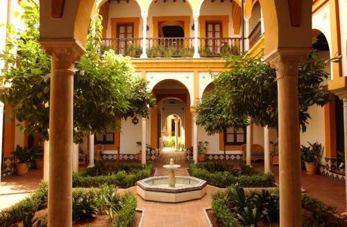 a courtyard with a fountain in front of a building at Hotel Casa Imperial in Seville