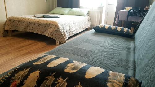 a bedroom with a bed and a rug on the floor at Apartment on Artushkova in Krasnodar