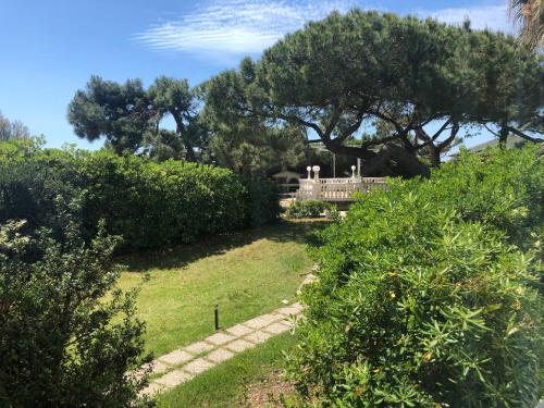a garden with trees and a house in the background at Domizia Palace Hotel in Baia Domizia