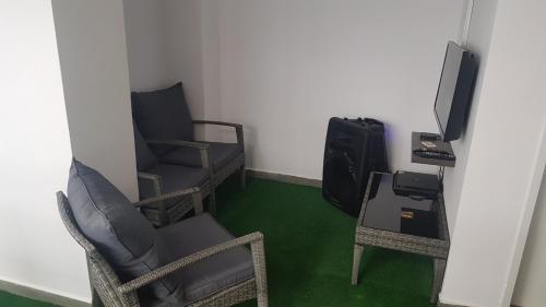 a room with two chairs and a tv and a table at House coffe in Burgas