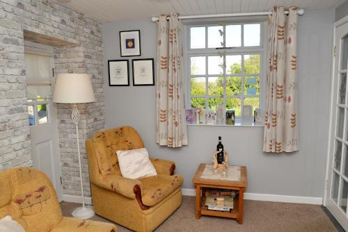 a living room with a chair and a table at Cloverhill Gate Lodge in Cloverhill