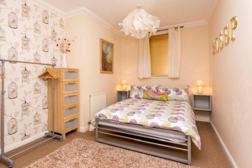 a bedroom with a bed and a chandelier at The Doocot in Colinsburgh