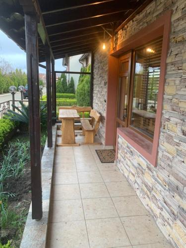 a patio with a table and a stone building at PANTELI APART HOUSE in Aheloy
