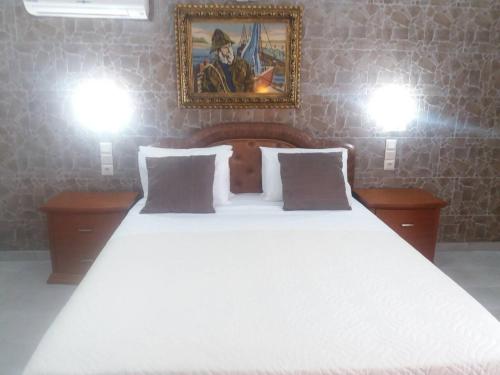 a bedroom with a large white bed with two lights at Laskas Apartment in Stalida