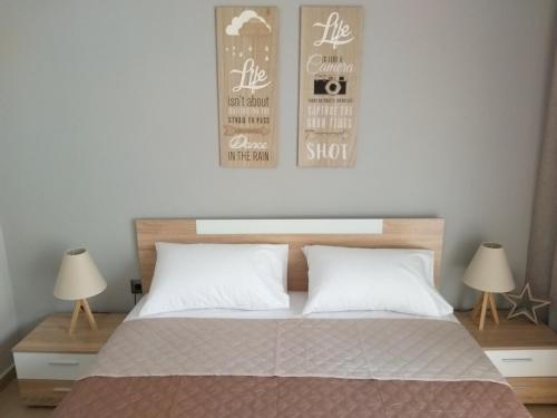 ein Schlafzimmer mit einem Bett mit zwei Lampen und zwei Postern in der Unterkunft Castle View Apartment in Kavala