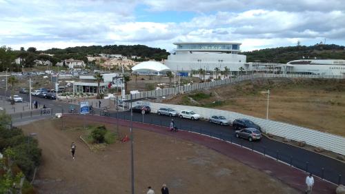 un parking avec des voitures garées devant un bâtiment dans l'établissement Studio Port Richelieu, au Cap d'Agde