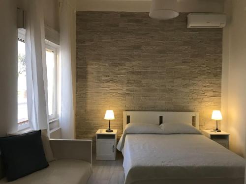een slaapkamer met een bed en een bakstenen muur bij Terra del SUD in Giovinazzo