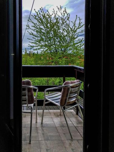 two chairs sitting on a balcony looking out a window at Apartment Franciska in Rakovica