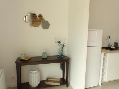 une cuisine avec une table et un réfrigérateur dans l'établissement Le Stepharion, à La Gaubretière