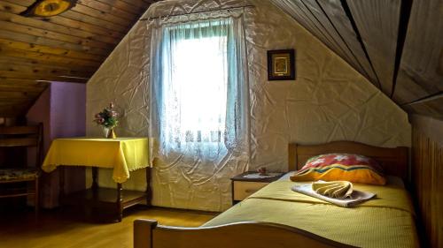 a bedroom with a bed with a window and a table at Apartment Franciska in Rakovica