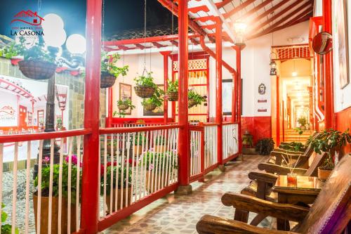 a restaurant with wooden benches and plants in a room at Hotel La Casona in Jardin