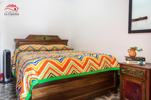 a bedroom with a bed with a colorful comforter at Hotel La Casona in Jardin
