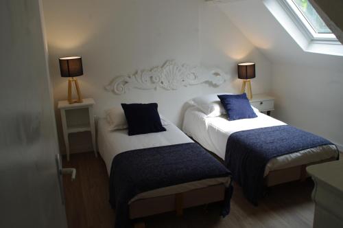 two beds in a small room with two lamps at La Cour Royale in Bayeux