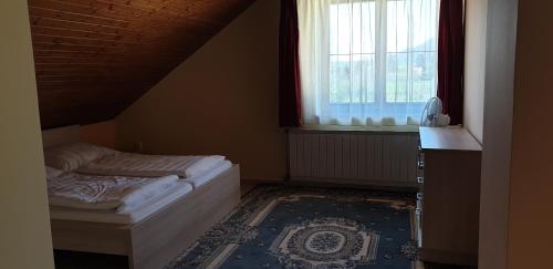 a bedroom with two beds and a window at Penzion Montana in Terchová